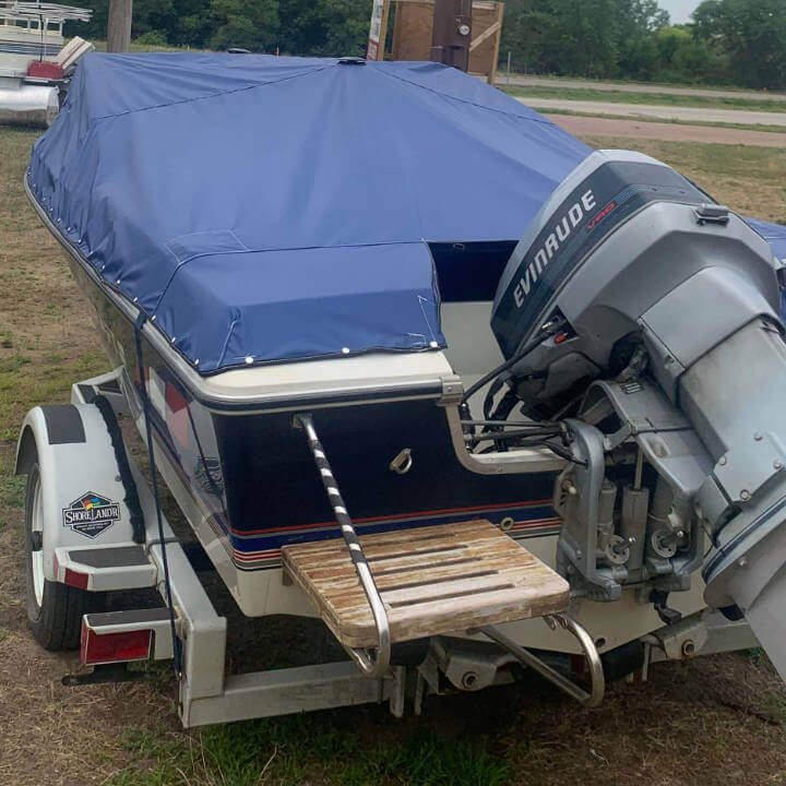 Boat with an out-board motor covered in a blue cover