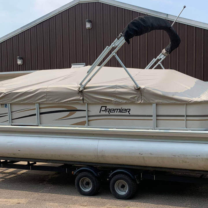 A pontoon with a cream colored cover